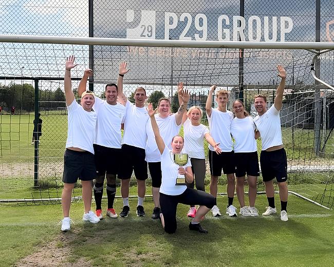 Das Team Tegernheim, bestehend aus neun Personen, posieren mit ihrem gewonnen Dorfpokal.